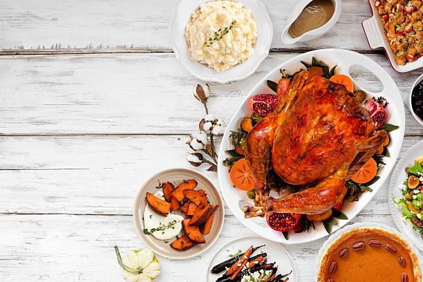 istock Thanksgiving turkey dinner. Overhead view side border on a rustic white wood table background. 2236438448