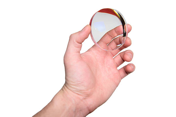Male hand holding optical eyeglass lens isolated on white background