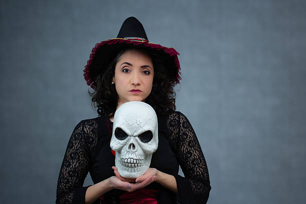 istock Powerful and sassy witch holding a skull under her chin, with a raised eyebrow. 2236448229