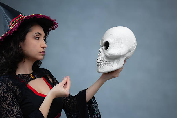 istock Funny witch talking to a skull and making an Italian hand gesture. 2236448238