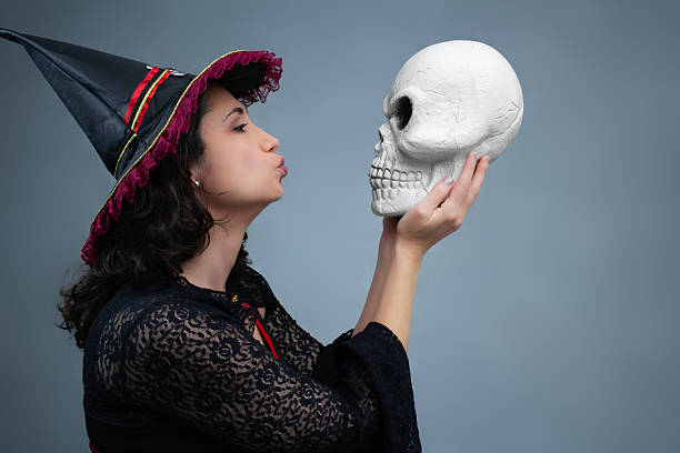 istock Completely in love witch blowing a kiss to a spooky skull. 2236448246