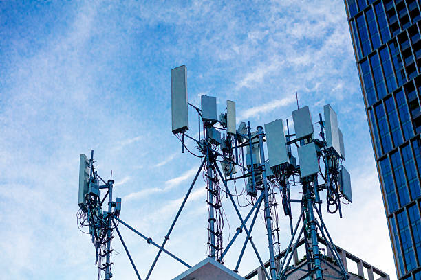 Several masts with 4g and 5g antennas high up on building in Bangkok