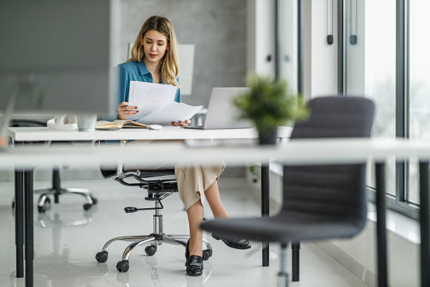 istock Professional woman reviewing documents in modern office environment during work hours 2236452367