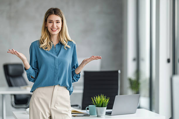 istock Professional woman smiling and gesturing in modern office setting during daytime 2236452406