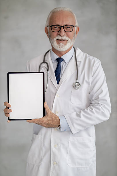 istock Doctor in a white coat smiling and holding a tablet in a clinical setting, ready to share information with patients 2236452672