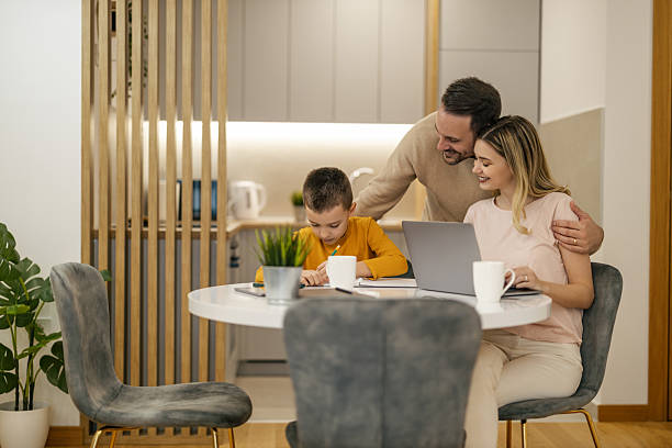 istock Family spends quality time together working on gadgets at their home kitchen table in the morning sun 2236453061