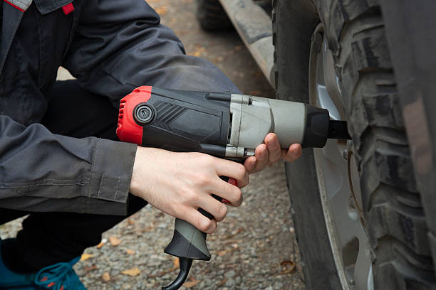 istock Tire service. Removing a wheel from a car using a wrench. 2236454029