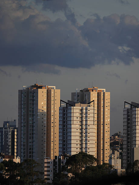 istock cityscape with several tall buildings under a cloudy sky, with some trees visible in the lower part of the image. 2236457879