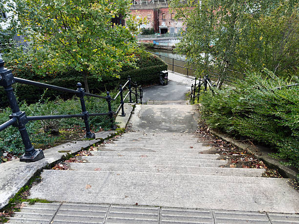 Staircase and greenery beside a canal in Manchester, featuring urban and natural elements.