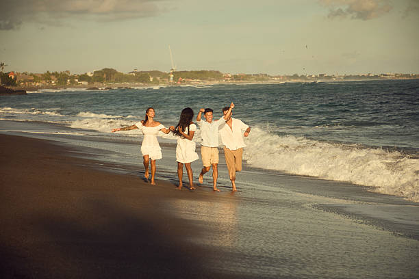 istock Group of friends enjoying a sunny day on a sandy beachfront 2236464788