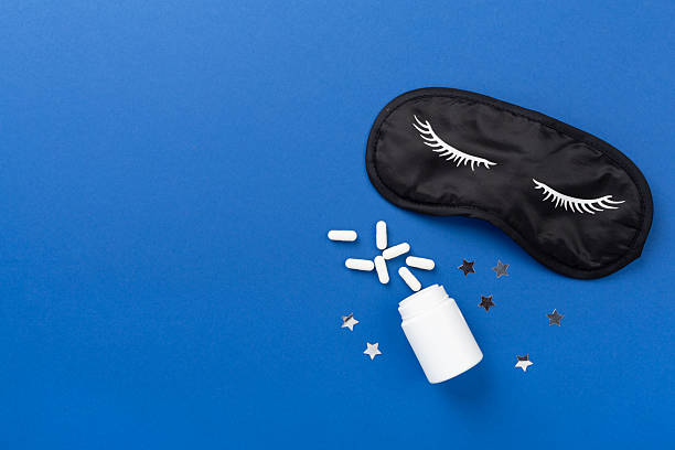 istock Sleeping mask with pills on color background, top view 2236468647