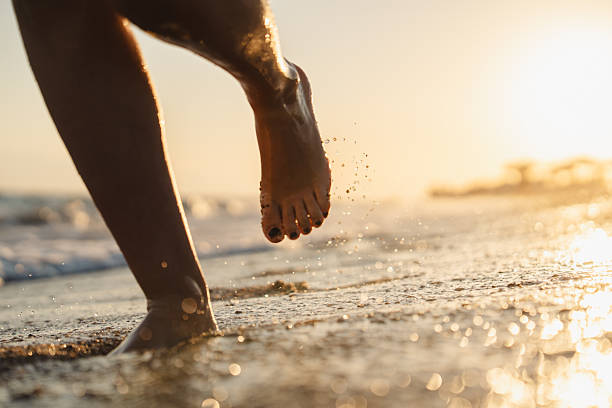 istock Woman running by the sea during sunset 2236471983