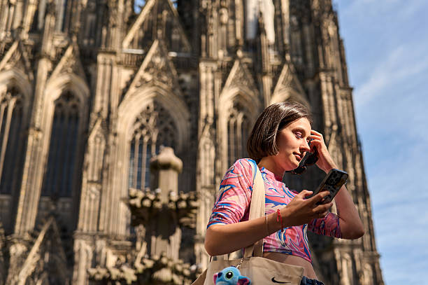 istock Woman using smartphone outside cologne cathedral in germany 2236472082