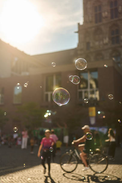 istock Soap bubbles floating in golden hour city square 2236473199