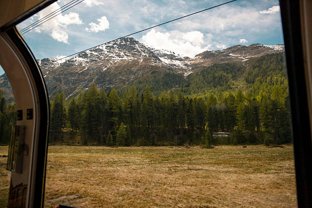 Travelling by train with big windows that shows nature landscapes in Swiss Alps