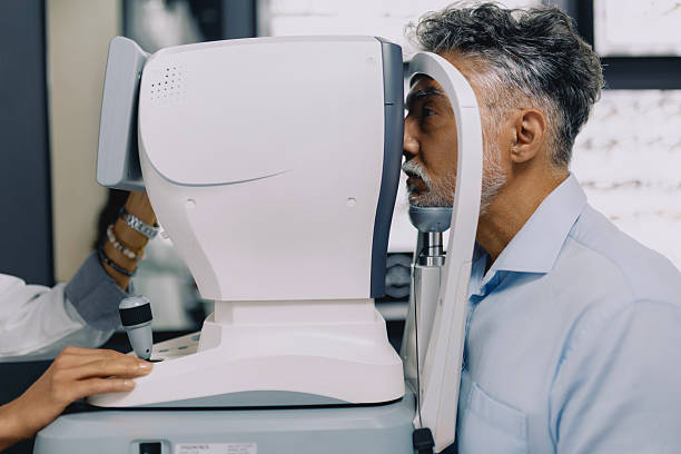 istock Man undergoing an eye examination as he positions himself at a vision testing machine in a modern optometry clinic. 2236475640