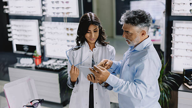 istock Female ophthalmologist assisting a customer in choosing eyeglass frames. 2236475705