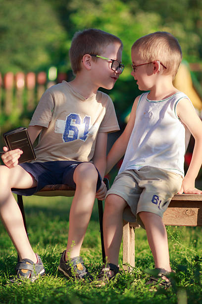 two Latino children sitting in the middle of a field resting at sunset