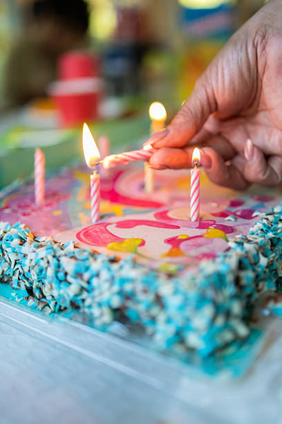 istock Hand lighting candles on birthday cake for celebration 2236478045