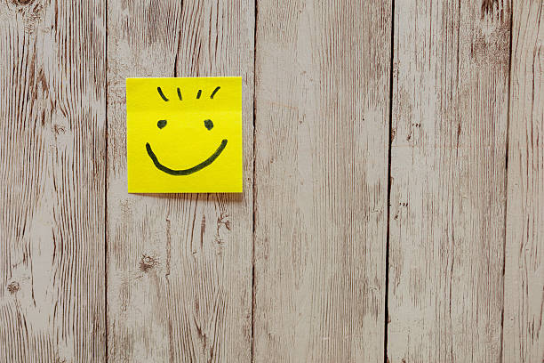 Happy smiling face in yellow background and torn white paper