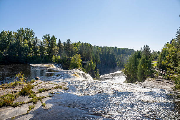 Kakabeka Falls, Ontario's stunning natural wonder, cascades powerfully through lush forests, offering mesmerizing scenic views and a serene escape into nature's beauty.