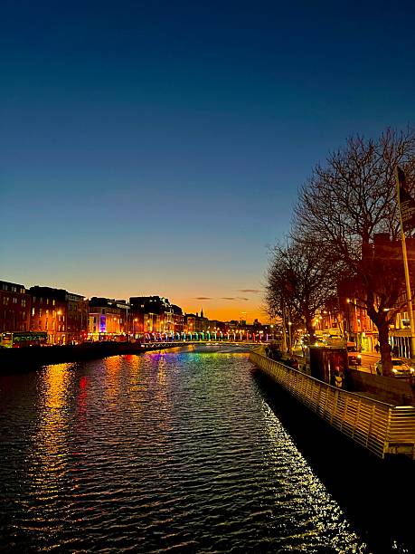 A gorgeous sunset capturing the beauty of central dublin, lights reflecting on water while the sky is painted in sunset colours