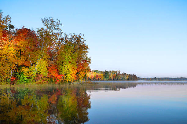 istock Autumn colored trees reflecting in lake 2236488957