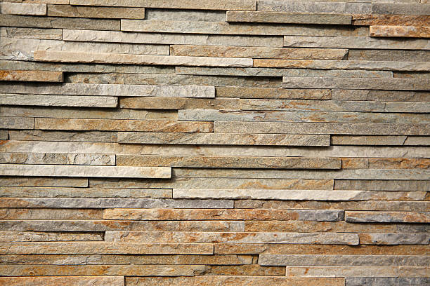 istock Close-up of a stacked stone wall with narrow rectangular slabs arranged in a horizontal pattern. 2236489557