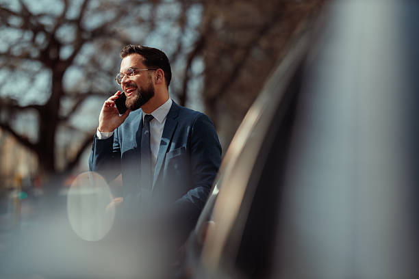 istock Businessman Talking on Phone by Car 2236489695
