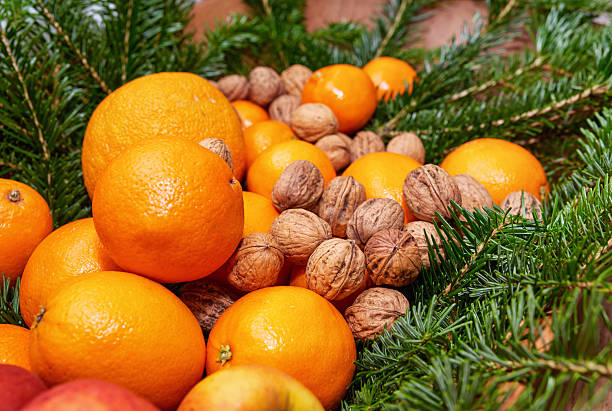 istock Festive still life featuring oranges, walnuts, and lush green pine branches 2236489982