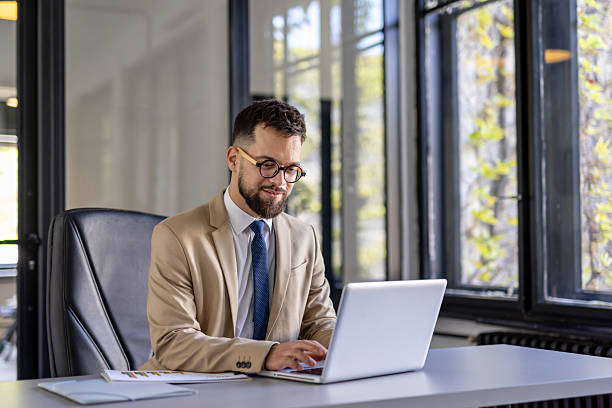 istock Confident businessman typing on laptop in modern office 2236490971