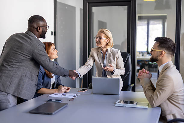 istock Business Professionals Celebrating Handshake At Conference 2236491000