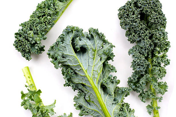 istock Fresh curly kale leaves with textured green surface. 2236492546