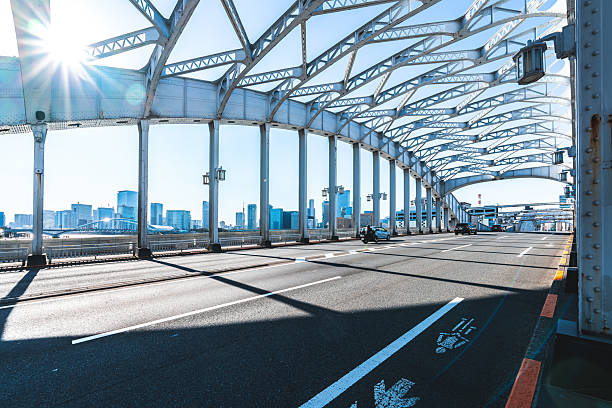 Tokyo city skyline seen through the metal structure of an urban bridge