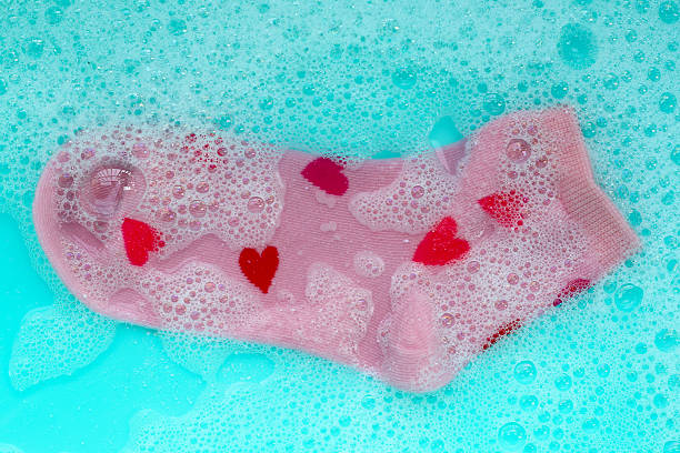 istock Pink socks with red heart patterns soaking in soapy water 2236496243