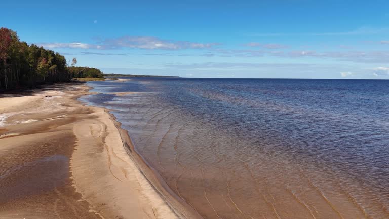 The drone takes off and shoots a landscape with a sandy beach on the shore of a blue sea without people. a beautiful place with a clean environment.