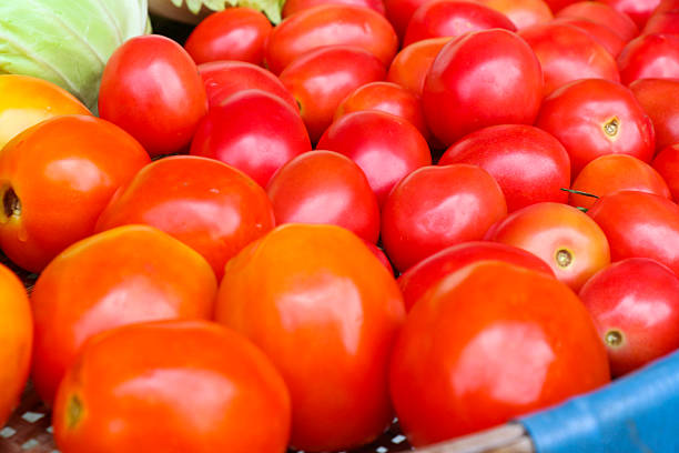 Close-up of stack of red tomatoes in supermarket display.  Full frame of produce market pile of fresh tomatoes.