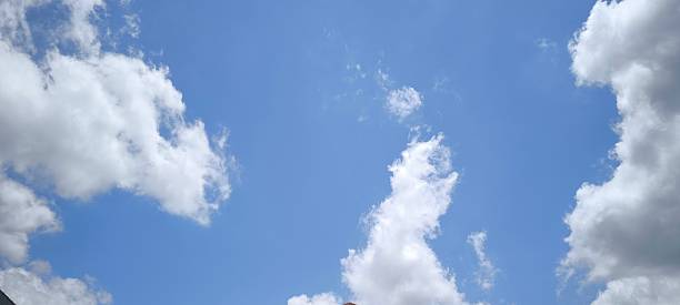 Scattered white clouds in a clear blue sky. Sky and cloud landscape. Sky background.