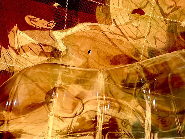 A glass object with a brownish tint and a patterned background. The background is a mix of red and brown colors
