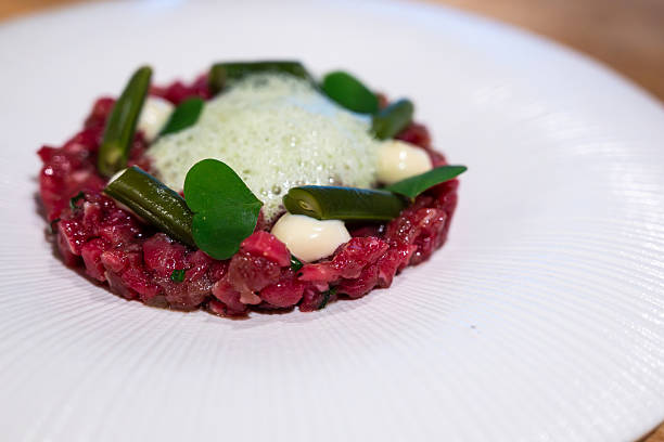 beef sirloin tartare with garnish served on a white plate