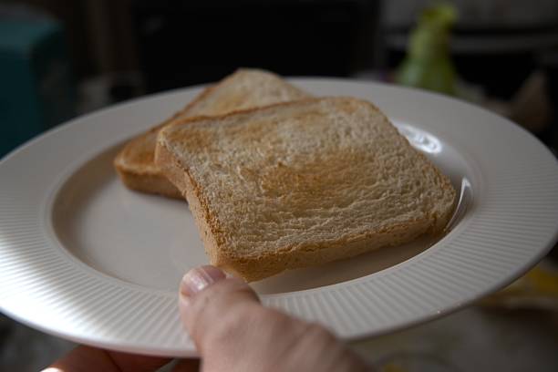 Two slices of toast on white plate, breakfast light