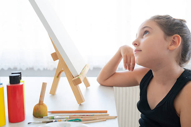 Little artist with pencil sketching on canvas