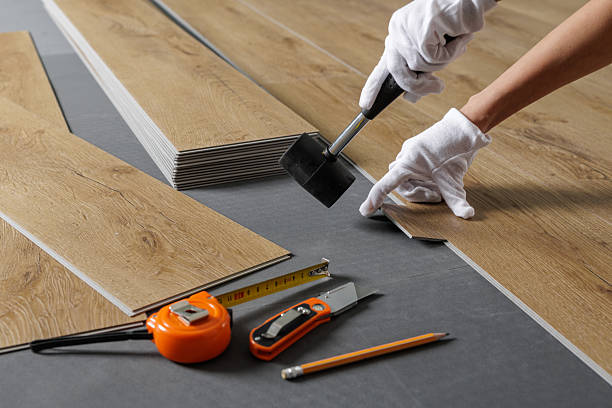istock Hands aligning SPC vinyl plank on underlayment with mallet during flooring installation 2236519463