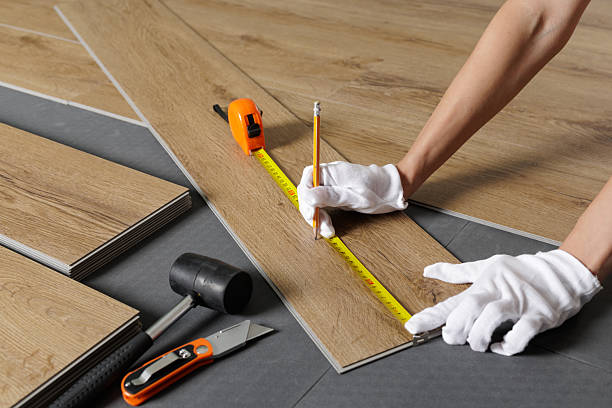 istock Hands measuring SPC vinyl plank with tape on underlayment during flooring installation 2236519470