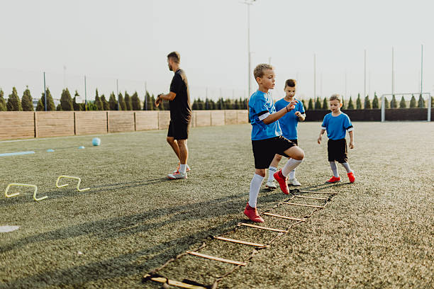 istock Coach instructing junior football team 2236520323
