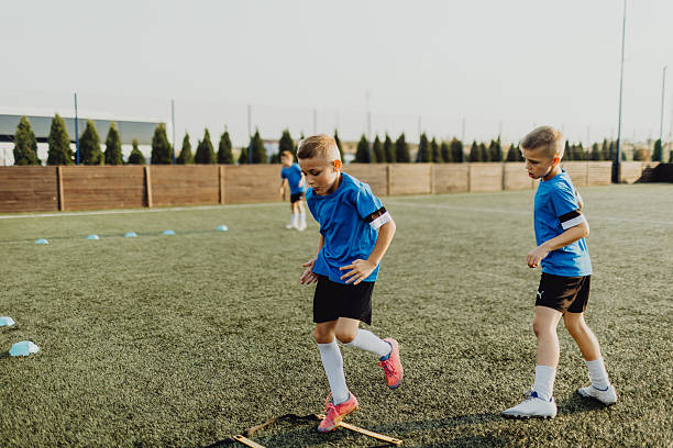 istock Group of boys jumping obstacles during training on soccer field 2236520455