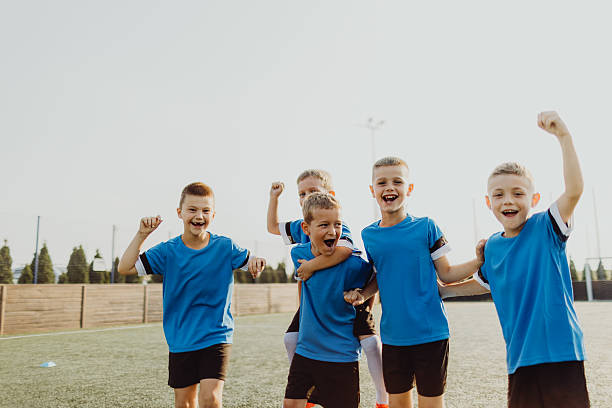istock Junior soccer team posing together on the field in blue uniforms 2236520742