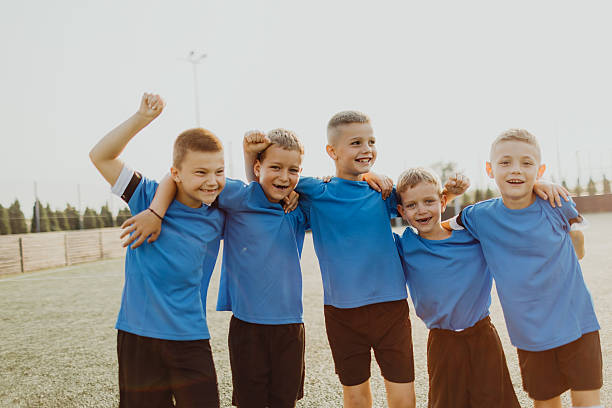 istock Junior soccer team posing together on the field in blue uniforms 2236520922