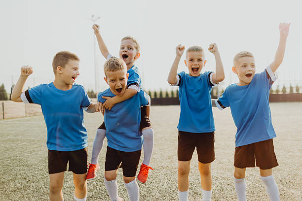 istock Junior soccer team posing together on the field in blue uniforms 2236521018