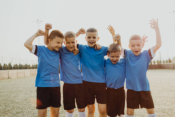 istock Junior soccer team posing together on the field in blue uniforms 2236521845